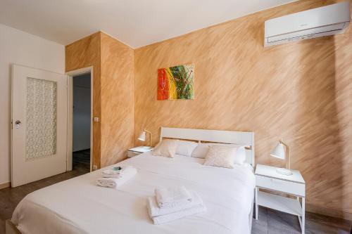 een slaapkamer met een groot wit bed en 2 nachtkastjes bij Licia Home - Air conditioning - Terrace in Sanremo