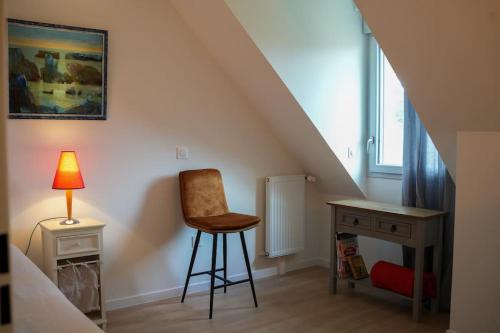 Cette chambre comprend un bureau, une chaise et une lampe. dans l'établissement Jolie maison neuve - 2 chambres, 2 salles de bain, à Saint-Valery-sur-Somme