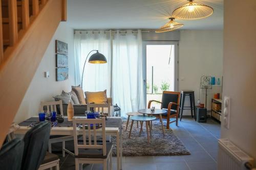 un salon avec une table et quelques chaises dans l'établissement Jolie maison neuve - 2 chambres, 2 salles de bain, à Saint-Valery-sur-Somme