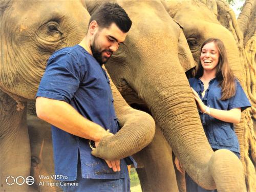 a man and a woman holding the trunk of an elephant at Hello countryside in Ban Khang Hong Tai