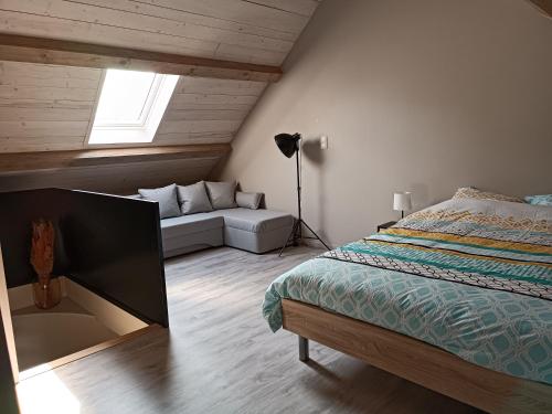 sypialnia z łóżkiem i kanapą w pokoju w obiekcie Clénoliette w mieście Cerfontaine