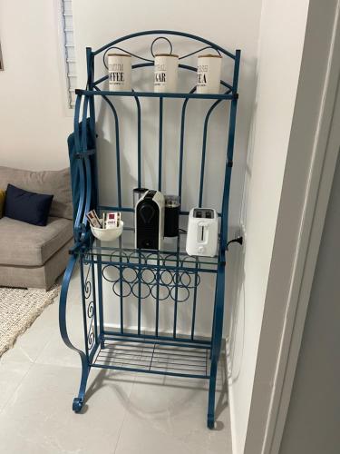 una repisa de hierro azul con tazas encima en una sala de estar en Nid D amour, en Petit-Bourg