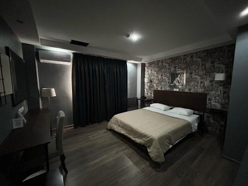 a bedroom with a bed and a table and a desk at Athina Airport Hotel in Thérmi