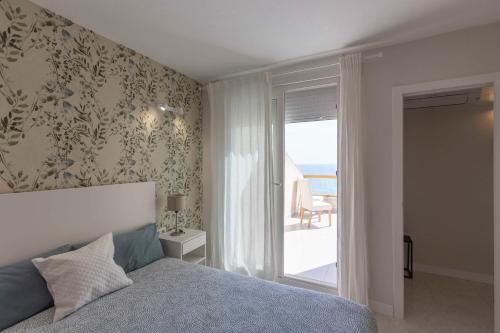 1 dormitorio con cama y vistas al océano en ATICO EN PRIMERA LÍNEA MEDITERRANEO, en Peñíscola