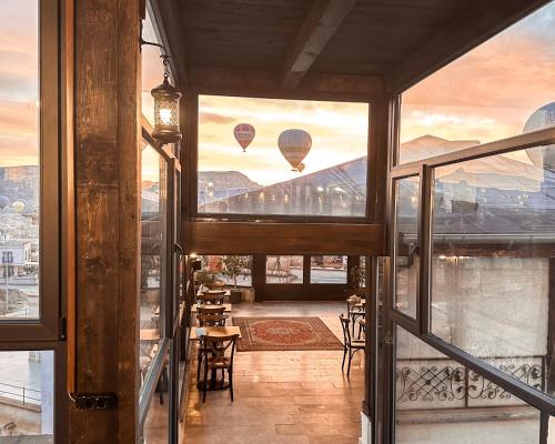 uma varanda com dois balões de ar quente no céu em Osmanli Cappadocia Hotel em Goreme