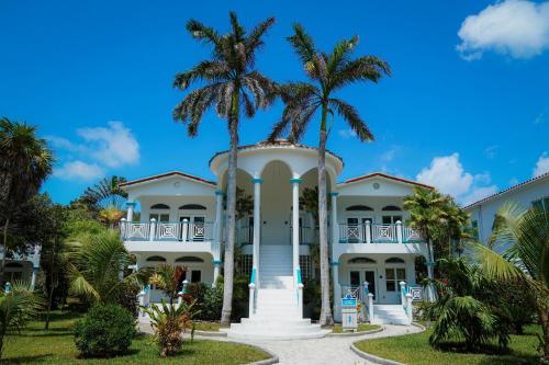 ein großes weißes Haus mit Palmen davor in der Unterkunft Margaritaville Beach Resort Ambergris Caye - Belize in San Pedro
