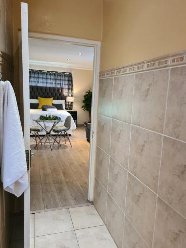 łazienka z prysznicem oraz sypialnia z łóżkiem w obiekcie Halfway Gardens Home w mieście Midrand