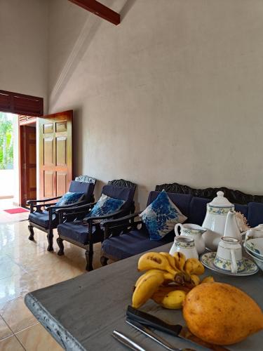 a living room with a table with bananas on it at The blue sky in Ahangama