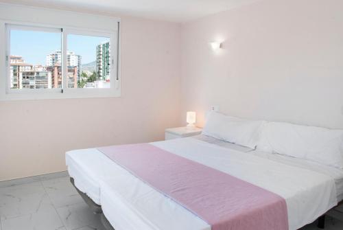 1 dormitorio blanco con 1 cama grande y ventana en Sunny rooftop in Los Boliches Ref 126, en San Francisco