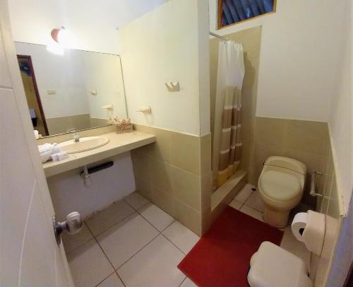 a bathroom with a toilet and a sink and a mirror at Mancora y Sol in Máncora