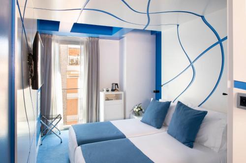 una camera da letto con un letto bianco con accenti blu di Allegro Barcelona a Barcellona