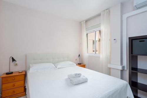 a bedroom with a white bed and a tv at Fuengirola old town accomodation Ref 134 in Fuengirola