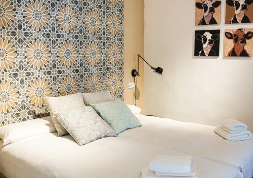 a bedroom with a white bed with a wall at Casa Rural Casa Levante in Arcos de la Frontera