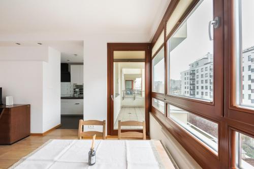 salon z dużym oknem i stołem w obiekcie Bemowo Rest Easy Apartment w Warszawie