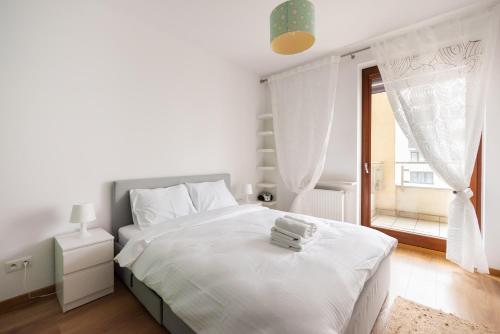 biała sypialnia z dużym łóżkiem i oknem w obiekcie Bemowo Rest Easy Apartment w Warszawie