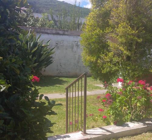 una puerta de metal en un jardín con flores rosas en Rancho Aparte en Salta