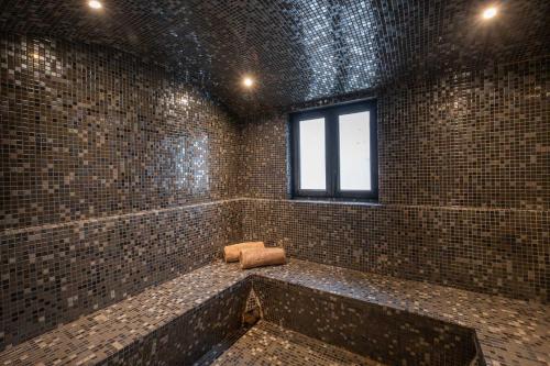 a bathroom with a brick wall and a window at LE M HOTEL & SPA HONFLEUR in Honfleur