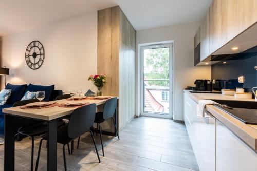 a kitchen and dining room with a table and chairs at Residence Polanica z sauną, Sun & Snow in Polanica-Zdrój