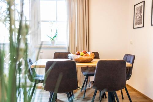 a dining room table with chairs and a bowl of fruit on it at Gasthof Fischerwirt in Zeutschach