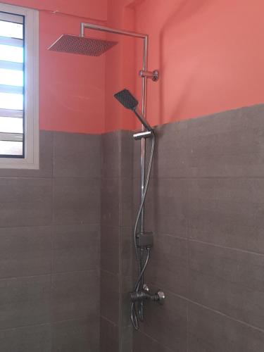 a shower in a bathroom with a red wall at VILLA BÖ LANME in Le Carbet