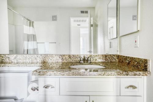 a white bathroom with a sink and a mirror at Sunnyvale 1BR w Pool WD Gym nr Google SFO-733 in Sunnyvale