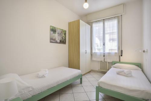 een kamer met 2 bedden en een raam bij Iris - Sweet Dreams in Florence in Scandicci