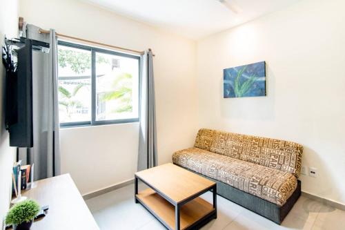 uma sala de estar com um sofá e uma janela em Viento Suites Cancún em Cancún