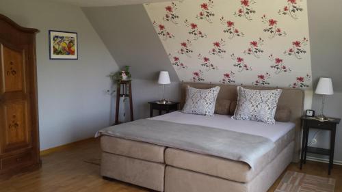 1 dormitorio con 1 cama con flores en la pared en Ferienwohnung Prinz, en Lathen