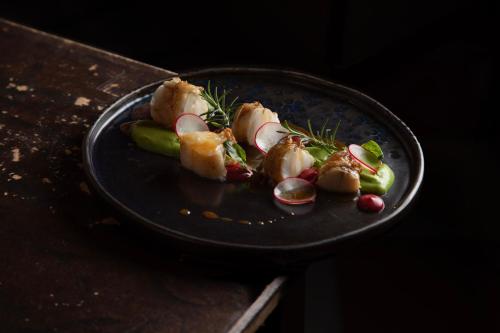 a plate of food with vegetables on a table at Locanda di Corte in Bosa