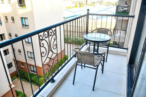 a balcony with a table and chairs on a balcony at Naze home lovely furnished apartment close to JKIA and SGR in Nairobi