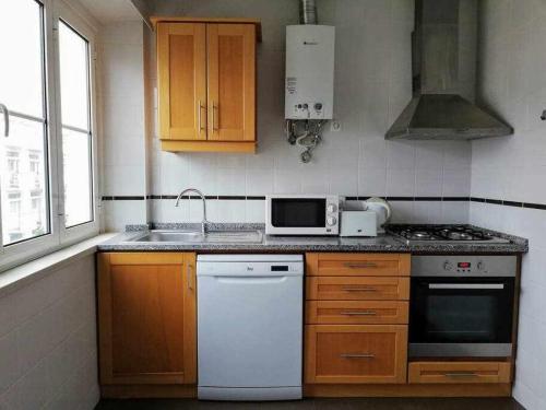 una cocina con fregadero y estufa horno superior en Apartamentos Internacional, en Coímbra