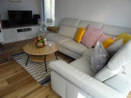 a living room with a white couch and a table at Kustverhuur, Park Schoneveld, Zeester 49 in Breskens
