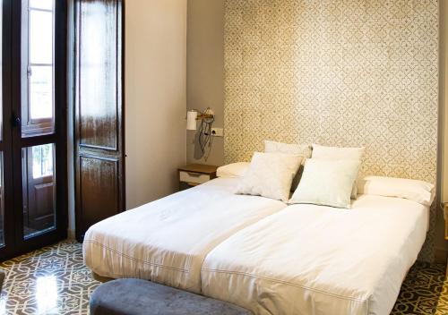 a bedroom with a large white bed in a room at Casa Rural Casa Levante in Arcos de la Frontera