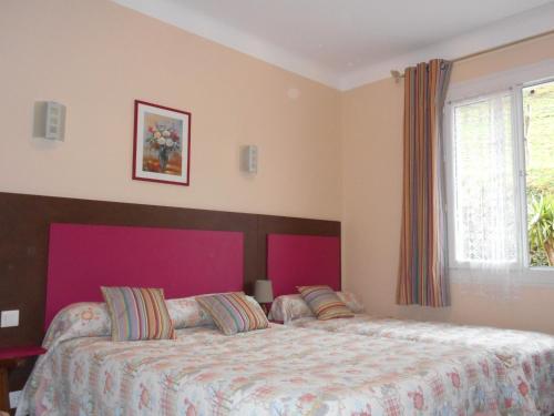 a bedroom with a large bed with a purple headboard at Les Sources de La Nive in Esterençuby