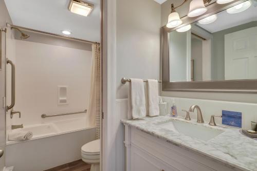 W łazience znajduje się umywalka, toaleta i lustro. w obiekcie 111 Water Street Inn w mieście Boyne City