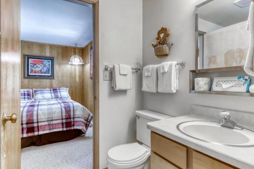 a bathroom with a toilet and a sink and a bed at Mt View Lane 7 | Discover Sunriver in Sunriver