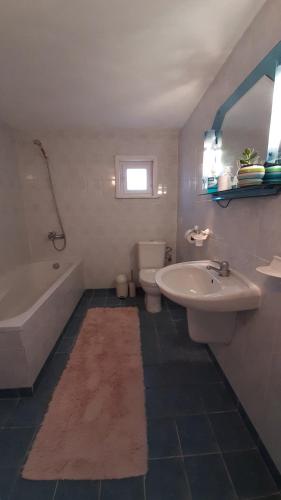 een badkamer met een wastafel, een bad en een toilet bij СЪНТОВЕЦ - къща за гости in Asparuchovo