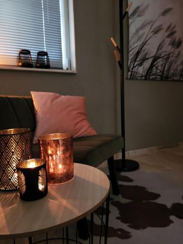 a living room with a couch and a table with candles at Secret Wellness Lonneker in Enschede