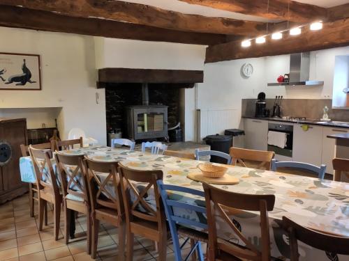 une grande salle à manger avec une table et des chaises dans l'établissement Maison familiale, 15couchages, de charme au cœur de la Bretagne - 20 min de Vannes, à Lizio