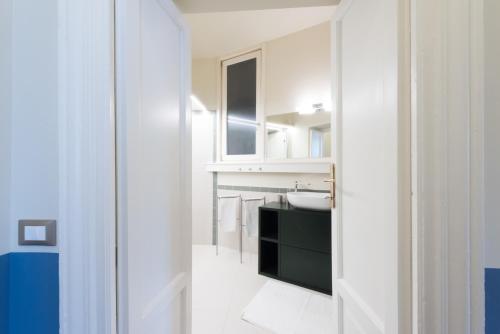 een witte badkamer met een wastafel en een spiegel bij Spazio Stoppani - BIG in Milaan