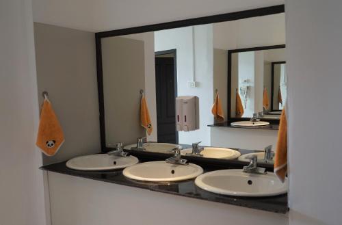 a bathroom with four sinks and two mirrors at Downtown Hostel in Luang Prabang