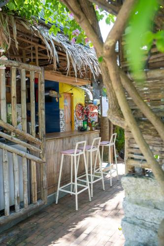 a bar with stools in front of a building at Cocohut Hoi An Homestay in Hoi An
