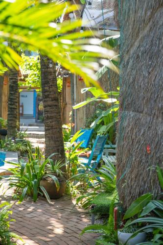 a patio with chairs and plants next to a building at Cocohut Hoi An Homestay in Hoi An