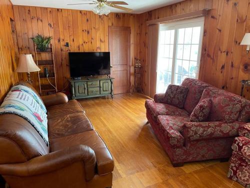a living room with a couch and a television at Home in Newland with River Views in Newland