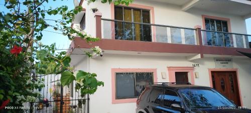 ein vor einem Haus mit Balkon geparktes Auto in der Unterkunft Casa Gacela Cozumel in Cozumel