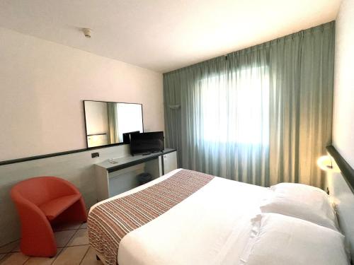 a hotel room with a bed and a mirror at Hotel Garden in Albissola Marina