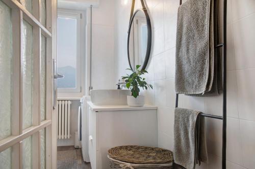 La salle de bains est pourvue d'un lavabo et d'un miroir. dans l'établissement Appartamento Stefano, à Luino