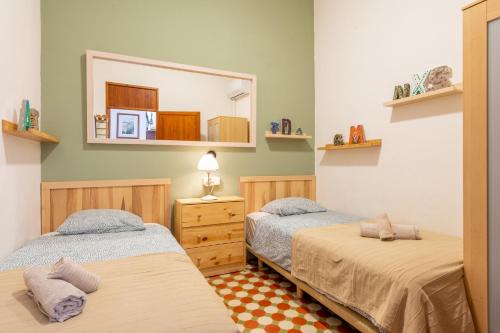 1 dormitorio con 2 camas y espejo en Sa Torre, en Puerto de Sóller