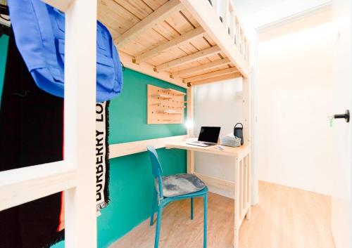 Zimmer mit einem Schreibtisch und einem Bett mit einem Laptop in der Unterkunft CoLiving - Lockhart Road 388 in Hongkong