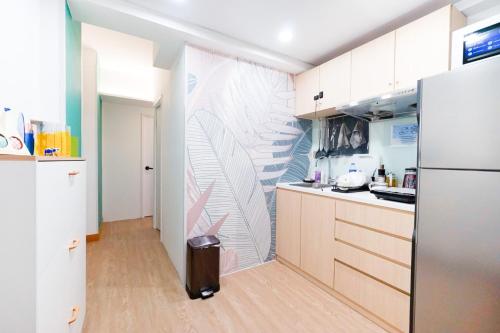 eine Küche mit weißen Schränken und einem Kühlschrank in der Unterkunft CoLiving - Lockhart Road 388 in Hongkong
